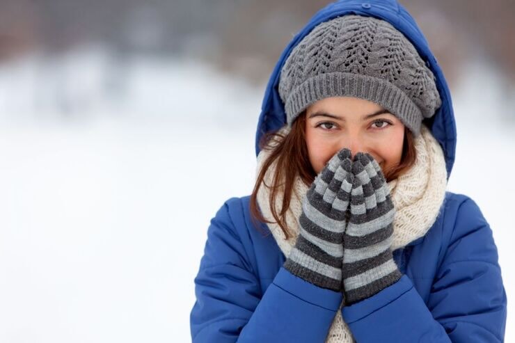 donna con guanti e cappello che sente freddo