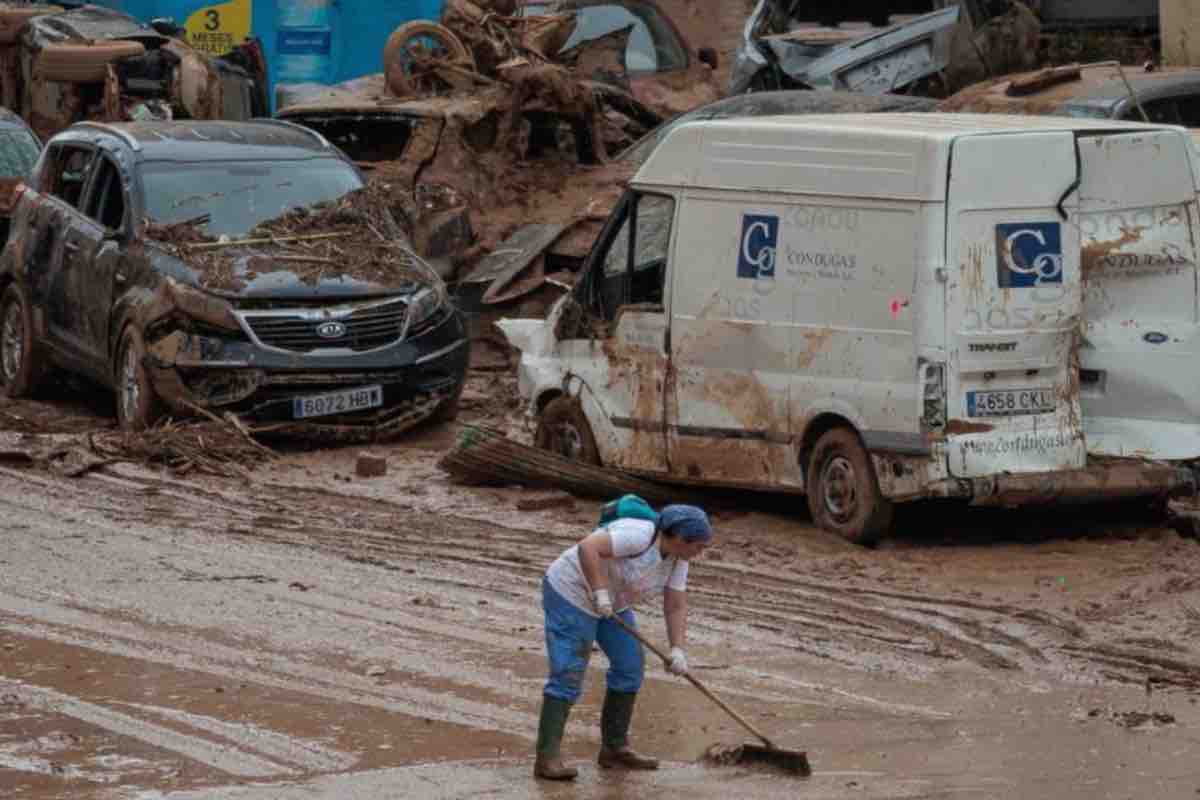 Signora spala il fango dopo alluvione di Valencia