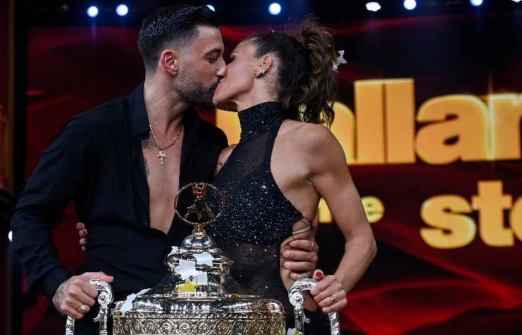 Il bacio celebrativo tra i vincitori di Ballando