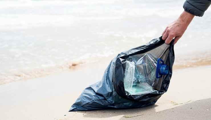 sacco spazzatura raccolta in spiaggia