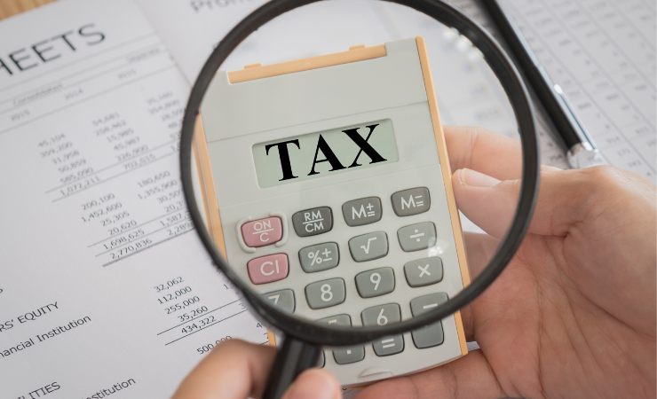 lente di ingrandimento su calcolatrice con scritta tax