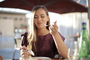 Ragazza bionda felice che mangia