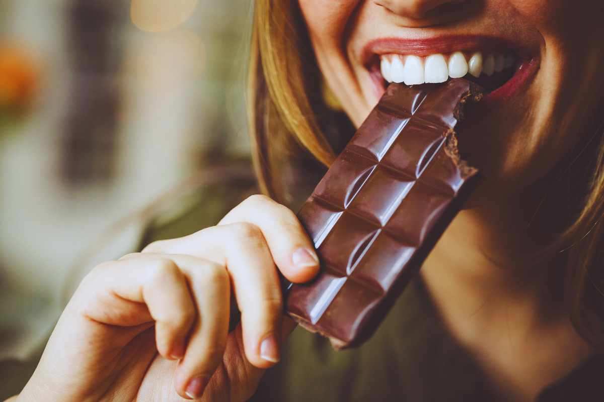 Donna che mangia una tavoletta di cioccolato