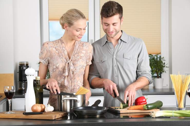 uomo e donna che cucinano insieme