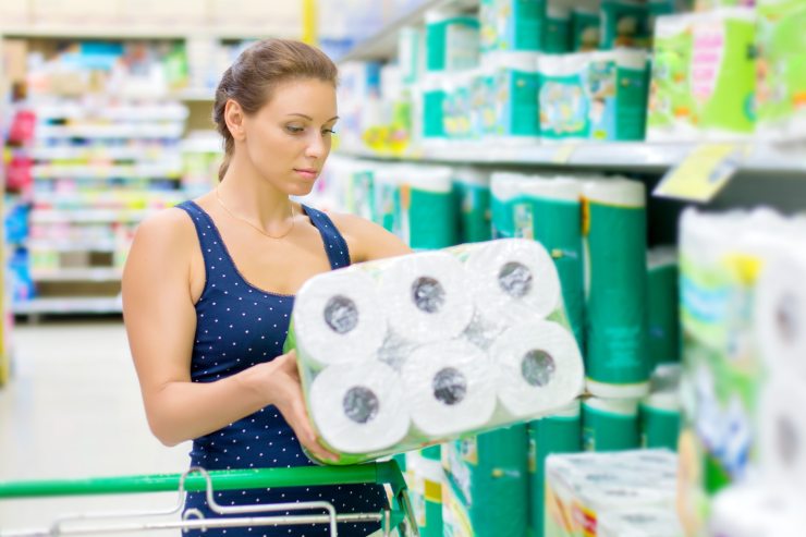 Ragazza che valuta la carta igienica al supermercato