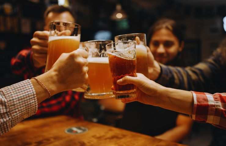 degli amici che brindano con dei boccali di birra